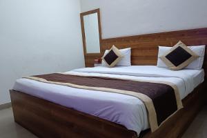 ein Schlafzimmer mit einem großen Bett mit einem hölzernen Kopfteil in der Unterkunft FabHotel Divine in Gurgaon