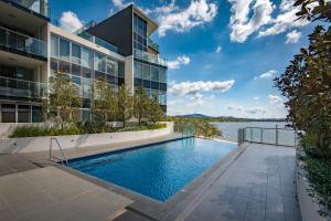 a building with a swimming pool next to a body of water at Lake View Apartment in Kingston in Kingston 