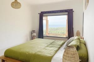 a bedroom with a bed with a large window at Villa Lombok Sunset w/Sea view in Mangsit +29 photos