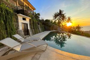 a swimming pool with two chairs and the sunset at Villa Lombok Sunset w/Sea view in Mangsit