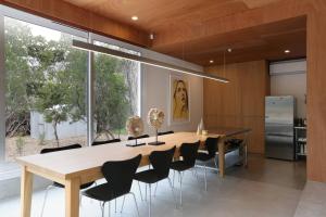 a dining room with a large wooden table and chairs at Rye Glass House - Architectural Escape in Rye