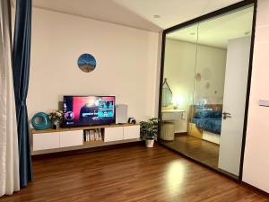 ein Wohnzimmer mit einem TV und einem großen Spiegel in der Unterkunft Green Diamond Homestay in Hạ Long