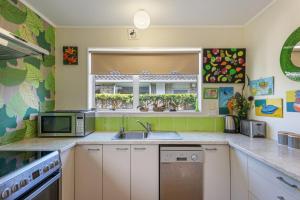 une cuisine avec un évier et une fenêtre dans l'établissement Olive Terrace - Paraparaumu Holiday Home, à Paraparaumu 9 autres photos