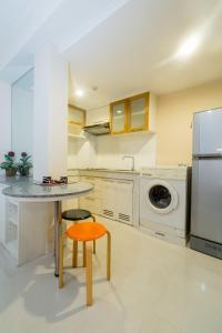 a kitchen with a table and a orange stool at Silom Convent Garden in Bangkok