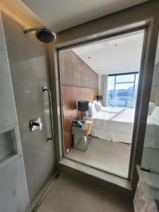 uma casa de banho com um espelho, uma cama e um chuveiro em Hotel Nacional no Rio de Janeiro