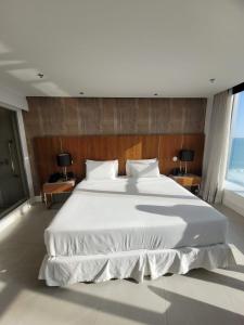 uma grande cama branca num grande quarto com janelas em Hotel Nacional no Rio de Janeiro