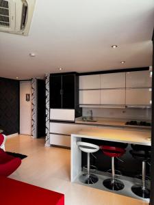 a kitchen with white cabinets and red bar stools at Blux 1305 Poblado Medellín Colombia in Medellín