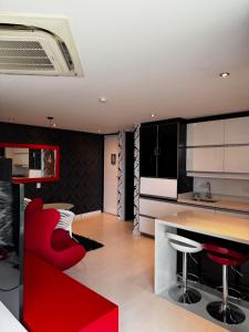 a kitchen with black and white cabinets and red chairs at Blux 1305 Poblado Medellín Colombia in Medellín +3 photos