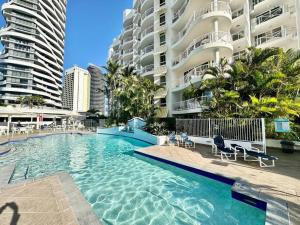 a swimming pool in front of a large building at French provincial style, Phoenician Broadbeach in Gold Coast