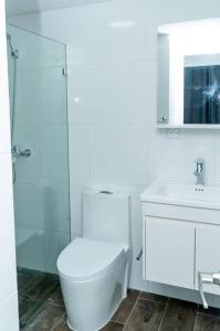 Baño blanco con aseo y lavamanos en “Hermoso Apartamento En Bávaro” en Punta Cana