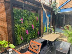 un patio con una mesa y una pared verde con flores en Silom Convent Garden - SHA Extra Plus, en Bangkok