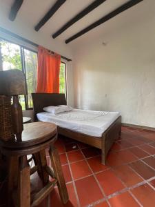 a bedroom with a bed and a chair and a table at Casa de campo La MariaCa in Utica