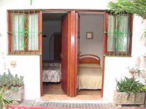 1 dormitorio con puerta abierta y cama en Pensión San Andrés I en Jerez de la Frontera