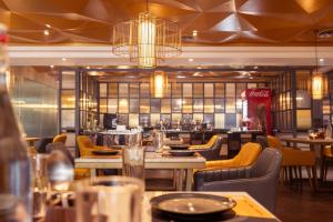 Un comedor con mesas y sillas y un restaurante. en Hotel NorthInn, en Mancherāl 7 fotos más