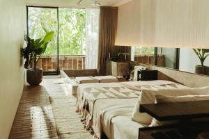 una camera d'albergo con tre letti e una finestra di Titik Dua ad Ubud