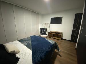 1 dormitorio con 1 cama, 1 silla y TV en TL Casa Blanca Hotel Boutique Sibundoy Putumayo, en Sibundoy