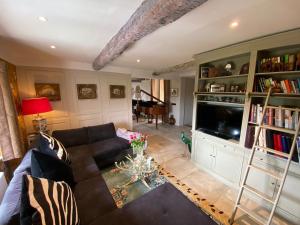 a living room with a couch and a television at Bastide de Peyloubet in Grasse