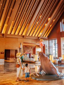 a woman and a child standing next to a sculpture in a lobby at DoubleTree by Hilton Shanwei in Shanwei