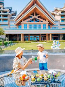 uma mulher e uma criança sentados à mesa com comida em DoubleTree by Hilton Shanwei em Shanwei