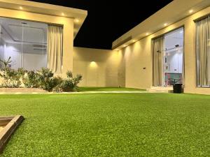 a yard with green artificial grass in front of a building at شاليه جود in Riyadh