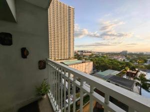 a balcony with a view of a tall building at Condo Near MOA, NAIA, PICC, & CCP that is comfy with a view! in Manila