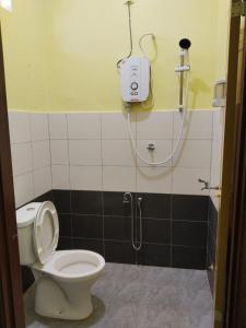 a bathroom with a shower and a toilet at Fadlim Homestay in Padang Serai