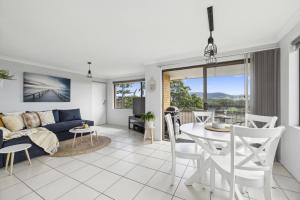 ein Wohnzimmer mit einem Sofa und einem Tisch in der Unterkunft Little Gem in Coffs Harbour