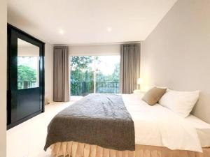 a bedroom with a large bed and a large window at Prime Hill , Kathu Phuket / F3 in Phuket Town