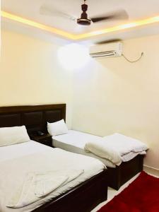 two beds in a room with a ceiling fan at Hotel Suramma Pvt. Ltd. in Rummindei