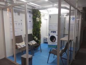 linda vista mar,2 quartos,Ocian SP في برايا جراندي: غرفة مع كراسي وغسالة ملابس