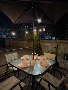 einen Tisch mit Tellern, Tassen und einem Regenschirm in der Unterkunft Walnut in Hamilton