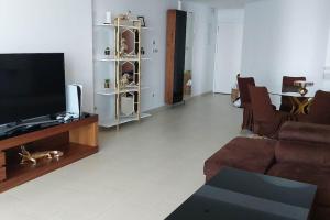 een woonkamer met een bank en een flatscreen-tv bij appartement de luxe haut standing les falaises in Oran