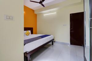 a bedroom with a bed with a ceiling fan at SPOT ON Hotel Aaradhya Inn in Bangalore