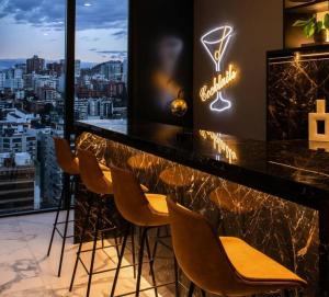 - un bar avec des chaises et une vue sur la ville dans l'établissement OG Stay: Urban Retreat in Quito, à Quito