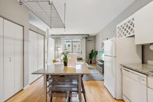 a kitchen with a table and a refrigerator at CozySuites Mill District with pool, gym #06 in Minneapolis
