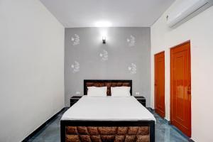 um quarto com uma cama grande e lençóis brancos em OYO Conifer INN em Meerut