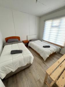 a bedroom with two beds and a wooden floor at Cabañas Little Home in Puerto Natales