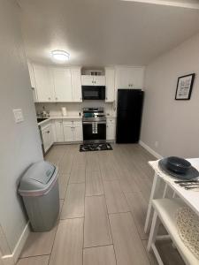 a kitchen with white cabinets and a black refrigerator at The Cove Downtown in Sacramento