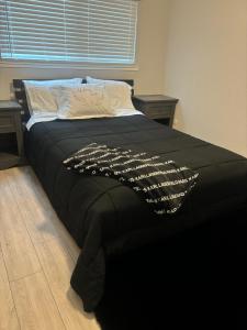 a black bed with a black comforter on it at The Cove Downtown in Sacramento