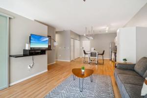 a living room with a couch and a table at CozySuites Mill District with pool, gym #08 in Minneapolis +30 photos