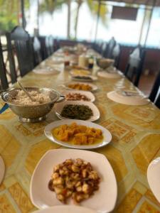 Sera Beach Dive Resort في Kododa: طاولة طويلة عليها أطباق من الطعام