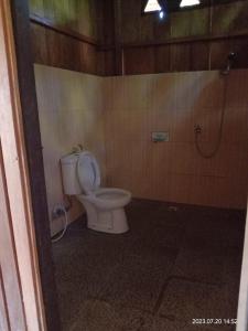 a bathroom with a toilet and a shower at Sera Beach Dive Resort in Kododa