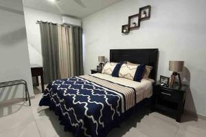 1 dormitorio con 1 cama con edredón azul y blanco en Alitas Doradas, en Mazatlán