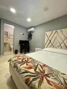 a bedroom with a bed and a bathroom with a piano at Casa Mango in Cali