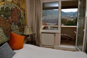a hotel room with a bed and a large window at Top View Apartaments in Braşov