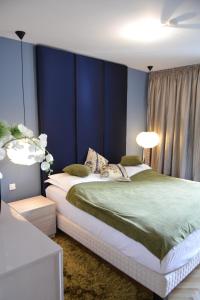 1 dormitorio con 1 cama grande y paredes azules en Top View Apartaments, en Brasov