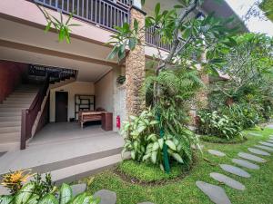 The Mudru Resort by Pramana Villas في أوبود: منزل امامه درج ونباتات