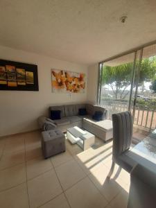 een woonkamer met een bank en een tafel bij APARTAMENTO 3 HABITACIONES - No aire acondicionado in Valledupar
