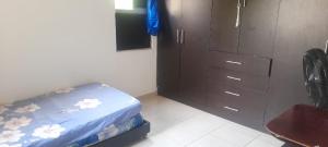 a bedroom with a bed and a dresser and a cabinet at APARTAMENTO 3 HABITACIONES - No aire acondicionado in Valledupar