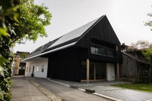 a black house with a gambrel roof at Maison rue de la rose in Ljubljana